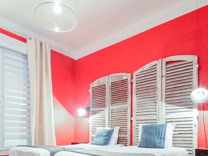 chambre 2 lits simples, tête de lits portes aspect vieilli, mur rouge